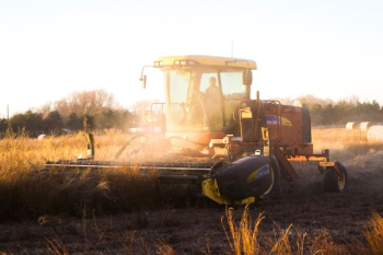 person riding brown combine harvester during daytime person riding brown combine harvester during daytime