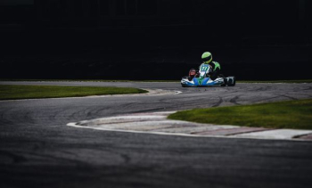 person riding go kart racing on race track person riding go kart racing on race track