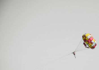 person riding on a parasailing during daytime person riding on a parasailing during daytime