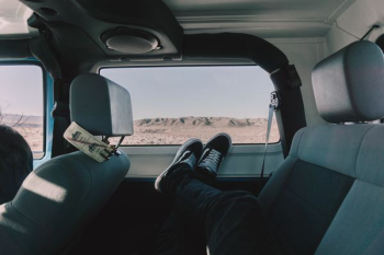 person's both feet on vehicle window person's both feet on vehicle window