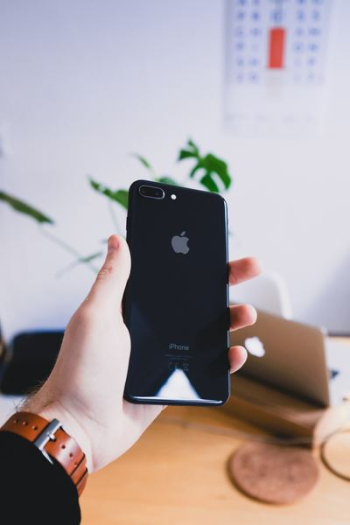 person's hand holding jet black iPhone 7 Plus person's hand holding jet black iPhone 7 Plus