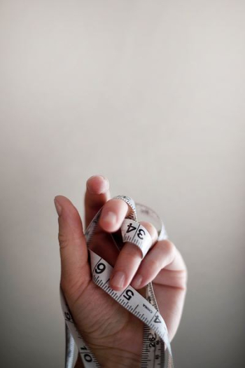 person's left hand wrapped by tape measure person's left hand wrapped by tape measure