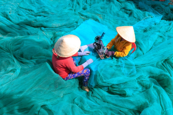Person Sewing Blue Nets