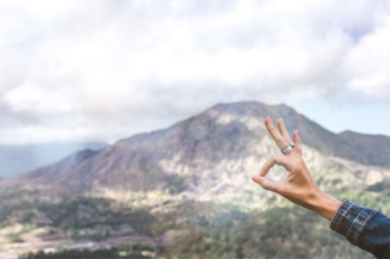Person Showing Ok Hand Sign Overlooking Mountain
