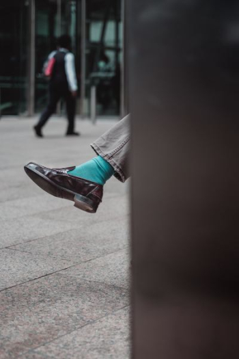 person showing unpaired brown leather dress shoe person showing unpaired brown leather dress shoe