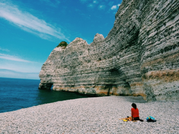 Person Sitting Beside Ocean Water Person Sitting Beside Ocean Water