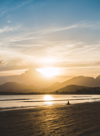 Person Sitting on Beach during Golden Hour Person Sitting on Beach during Golden Hour