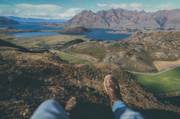 person sitting on cliff during daytime person sitting on cliff during daytime