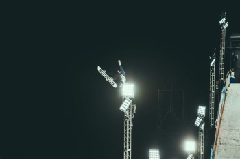 person snowboarding making stunts during nighttime