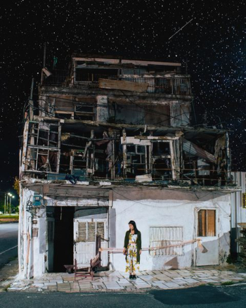 person standing near white concrete building during night time