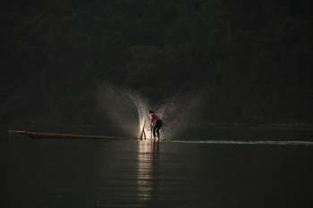 person standing on boat playing water person standing on boat playing water