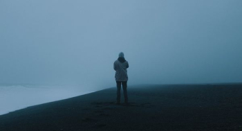 person standing on hill covered by fog person standing on hill covered by fog
