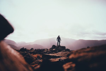 person standing on huge rock person standing on huge rock