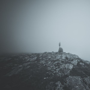 person standing on rock on top of hill person standing on rock on top of hill