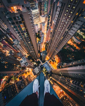 person standing on top of high-rise building person standing on top of high-rise building