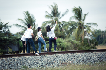 Person Taking a Selfie With Three Persons on Train Railway
