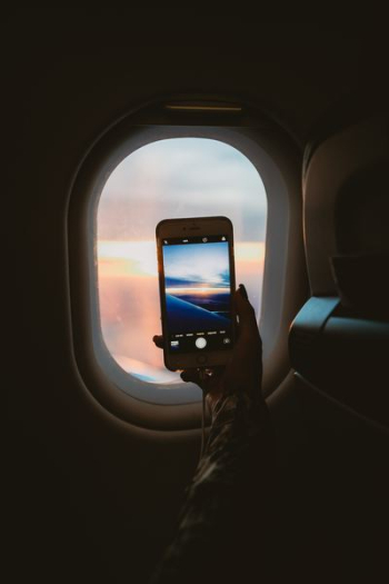 person taking picture of window plane person taking picture of window plane