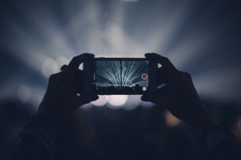 person taking video of live concert person taking video of live concert