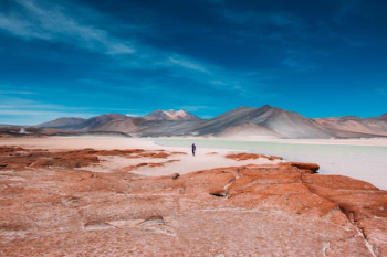 person walking in distance of mountain person walking in distance of mountain