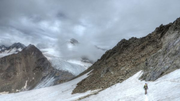 person walking on snow covered mountain during daytime person walking on snow covered mountain during daytime