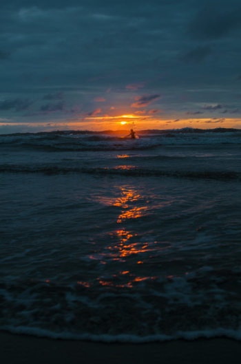 Person Walking Towards Beach Wave during Golden Hour Person Walking Towards Beach Wave during Golden Hour