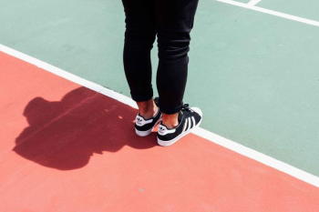 person wearing black adidas sneakers person wearing black adidas sneakers