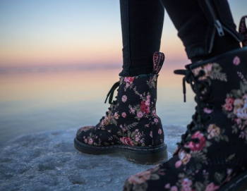 person wearing black and pink floral boots person wearing black and pink floral boots