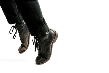 person wearing black leather dress shoes tip toeing