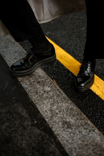 person wearing black patent leather dress shoes