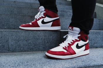 person wearing pair of red-and-white Air Jordan 1 shoes person wearing pair of red-and-white Air Jordan 1 shoes