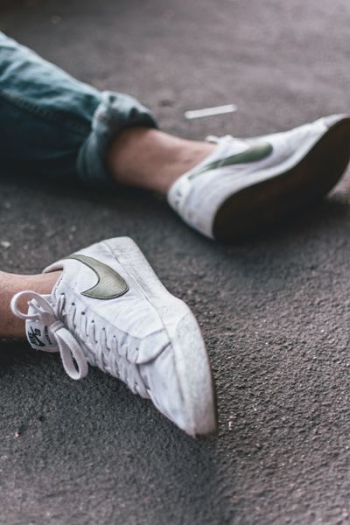 person wearing pair of white Nike sneakers person wearing pair of white Nike sneakers
