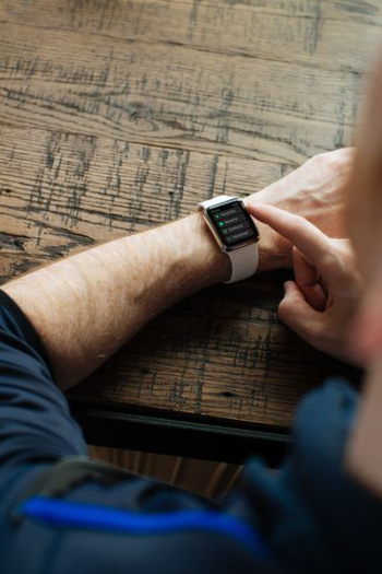 person wearing silver Apple Watch with white band person wearing silver Apple Watch with white band
