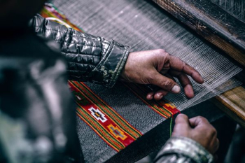 person weaving gray cloth person weaving gray cloth