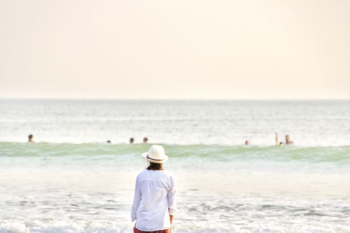 person with hat standing front of sea at daytime person with hat standing front of sea at daytime