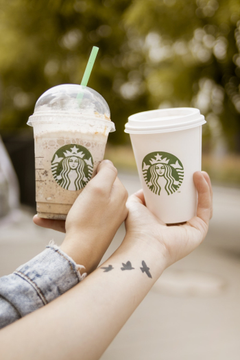 Persons Holding Starbucks Cups Persons Holding Starbucks Cups