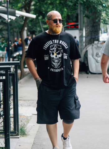 Photo of Bald Tattooed Man Walking on Side Walk Photo of Bald Tattooed Man Walking on Side Walk