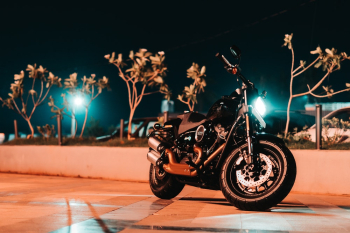 Photo of Black Motorcycle Parked On Pavement Photo of Black Motorcycle Parked On Pavement