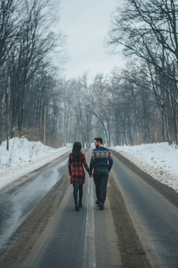 Photo of Couple Walking on Road Near Bare Trees Photo of Couple Walking on Road Near Bare Trees