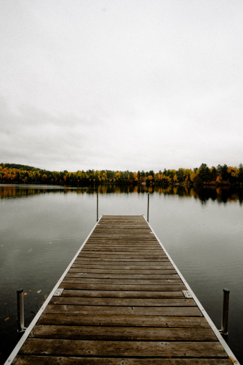 Photo of Empty Wooden Dock over Tranquil Lake Photo of Empty Wooden Dock over Tranquil Lake