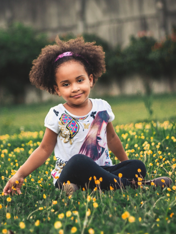 Photo of Girl Sitting On Flower Field Photo of Girl Sitting On Flower Field