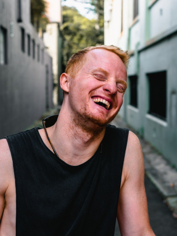 Photo of Man Laughing Between Buildings Photo of Man Laughing Between Buildings