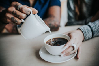 photo of man pouring milk on coffee photo of man pouring milk on coffee