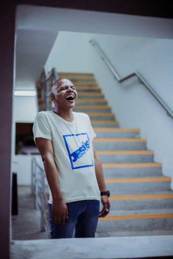 Photo of Man Standing Near Stairs Laughing Photo of Man Standing Near Stairs Laughing