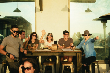 Photo of People Sitting on Chairs Near Wooden Table Photo of People Sitting on Chairs Near Wooden Table