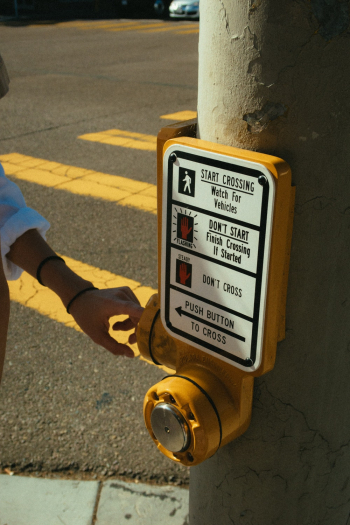 Photo of Person's Hand Near the Warning Sign Photo of Person's Hand Near the Warning Sign