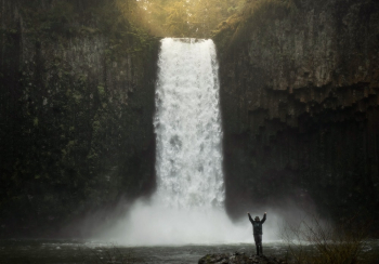 Photo of Person Standing Near Waterfalls Photo of Person Standing Near Waterfalls