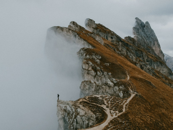 Photo of Person Standing on Cliff Edge