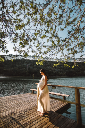 Photo Of Pregnant Woman Standing On Dock 