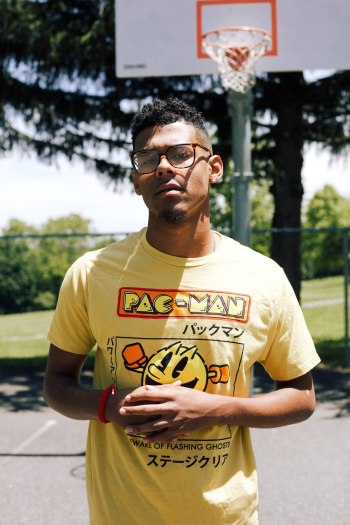 Photo of Standing Man in Yellow Pac-man T-shirt Standing in Basketball Court