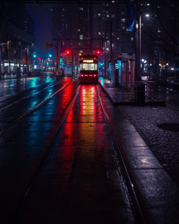 photo of tram beside waiting station during nighttime photo of tram beside waiting station during nighttime